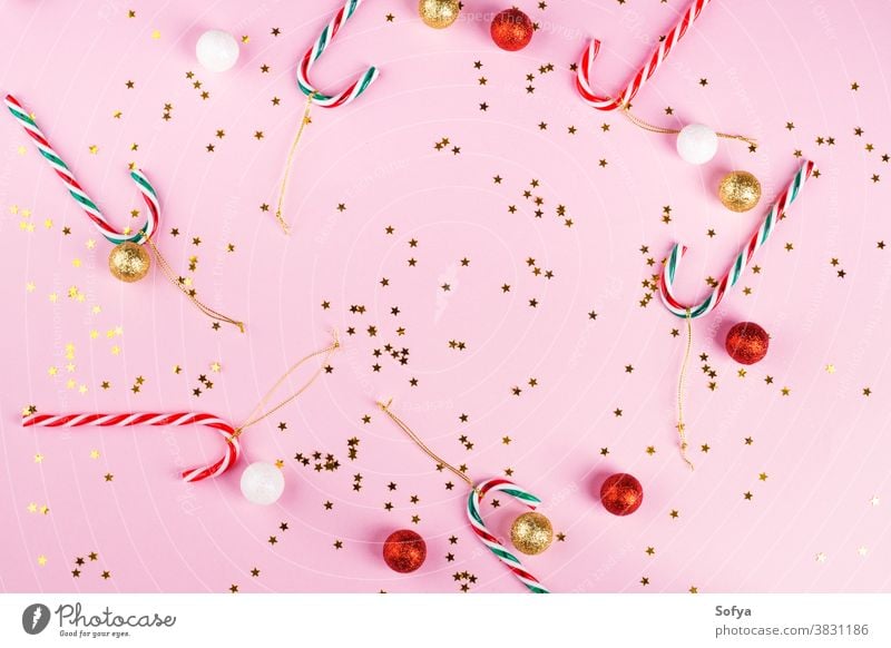 Weihnachtsrahmen auf rosa mit Konfetti, Zuckerstangen Weihnachten Neujahr Hintergrund Rahmen Dezember flache Verlegung Farbe trendy golden Stern funkelnd