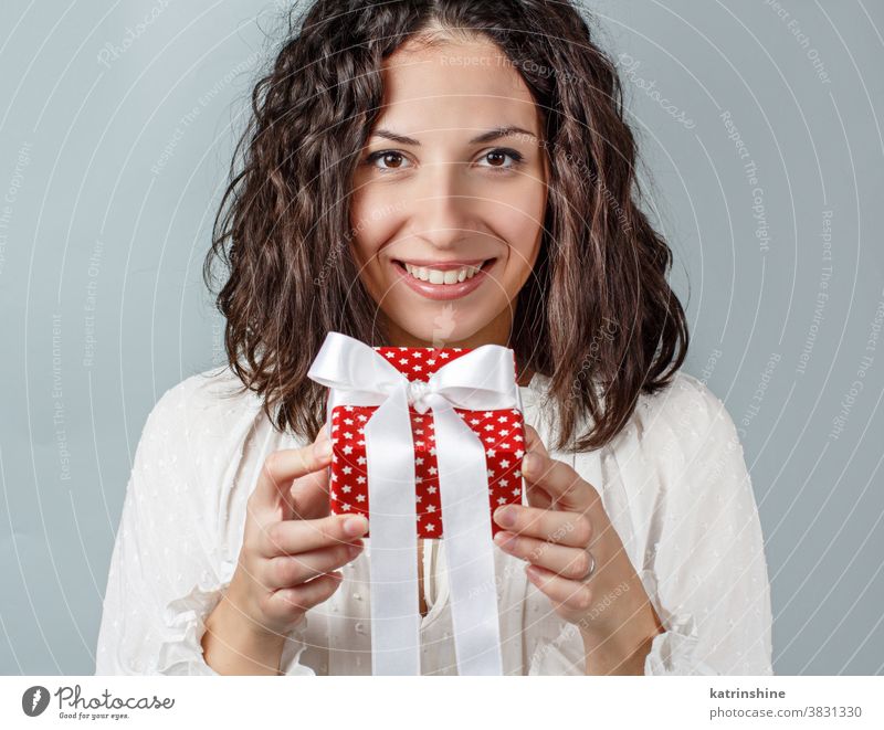 Junge Frau hält Geschenkpaket aus nächster Nähe in den Händen jung Geschenkverpackung Weihnachten gesichtslos weiß vereinzelt rot grau abschließen eingewickelt