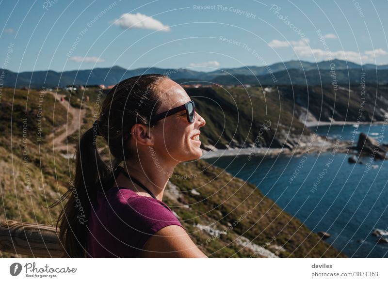 Weiße Frau genießt die Sonne und die Aussicht an der Kantabrischen See in Spanien. Norden Asturien sich[Akk] entspannen lässig T-Shirt Abenteuer Berggipfel weiß