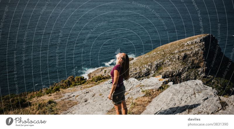 Frau, die an der Küste auf der Spitze einer Klippe steht, mit dem Meer im Hintergrund. Nizza inspirierend besinnlich Küstenlinie Sightseeing Reisender