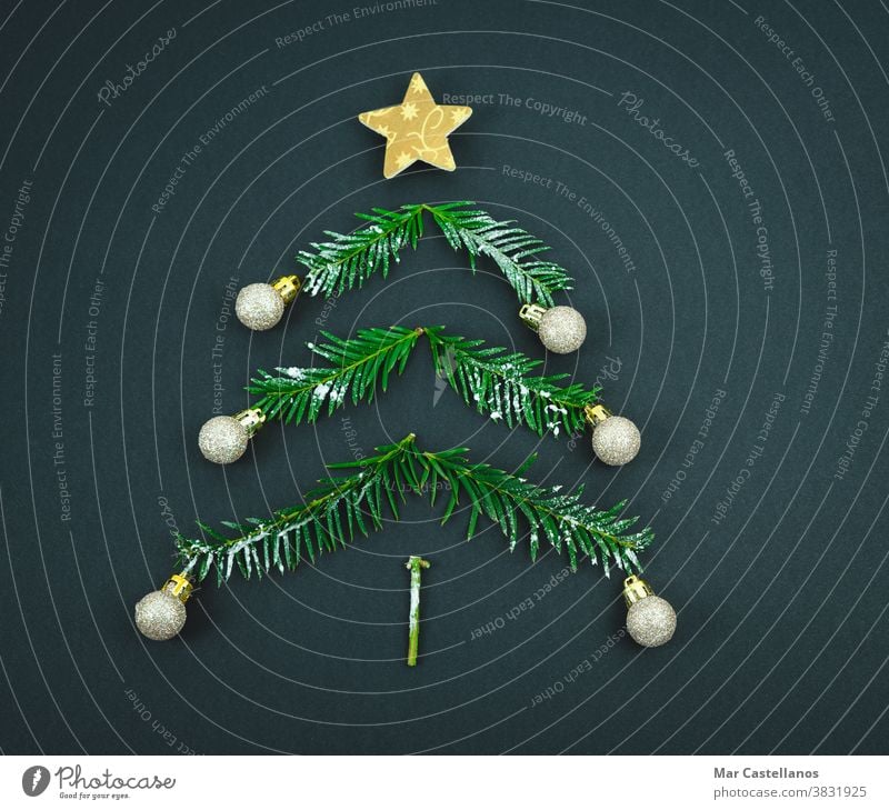 Weihnachtsbaum mit Stern und Kugeln aus Kiefernzweigen auf schwarzem Hintergrund. Leerzeichen kopieren. Dekoration & Verzierung Weihnachten Ende des Jahres Baum