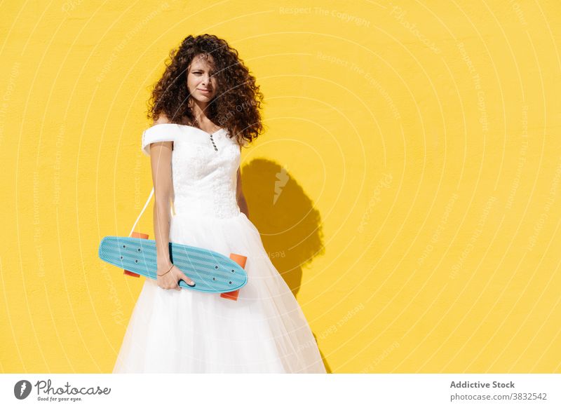 Trendy Frau im Brautkleid auf Skateboard cool Hipster weißes Kleid Hochzeit Stil heiter pulsierend Glück Longboard Halt Kultur stehen Skater Straße Generation
