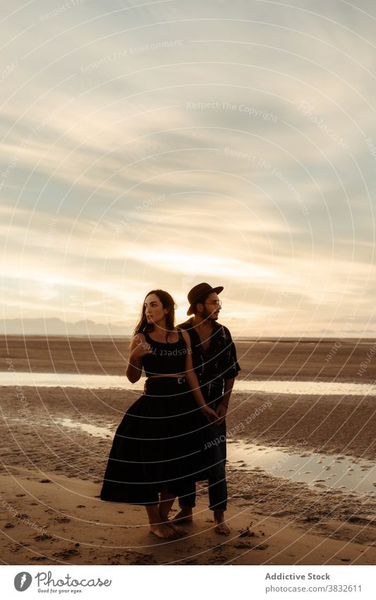 Paar stehend auf nassem Sand bei Sonnenuntergang Strand Händchenhalten Liebe Termin & Datum romantisch amourös sanft Valentinsgruß Mann Frau Freundin Stil