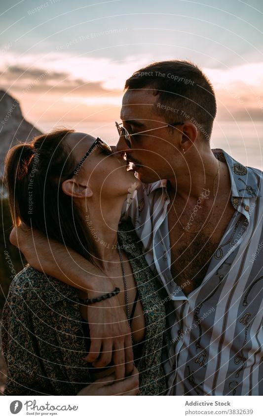 Verliebtes Paar, das sich bei Sonnenuntergang küsst Kuss MEER Leidenschaft Liebe amourös kuscheln Hügel Partnerschaft Umarmen romantisch Zuneigung Zusammensein