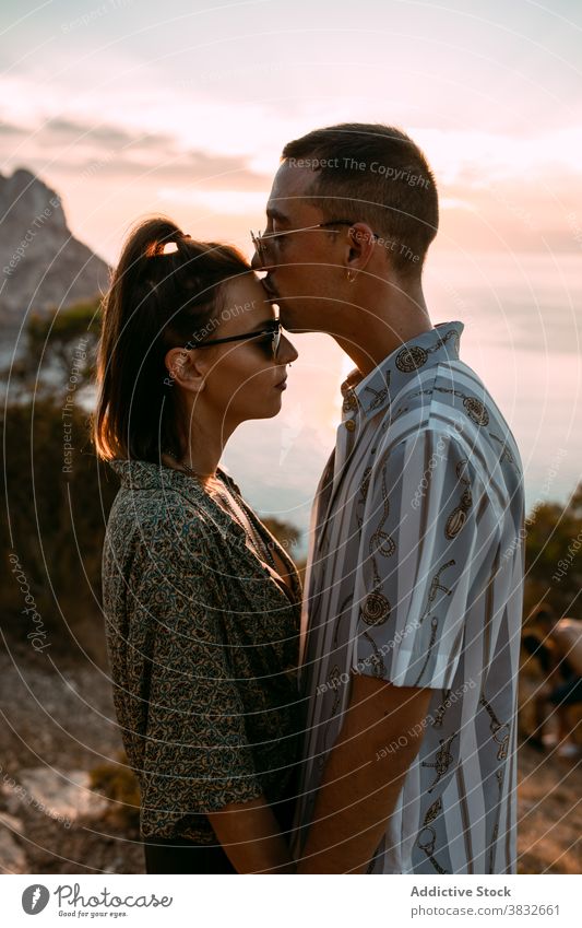 Verliebtes Paar, das sich bei Sonnenuntergang küsst Kuss MEER Leidenschaft Liebe amourös kuscheln Hügel Partnerschaft Umarmen romantisch Zuneigung Zusammensein
