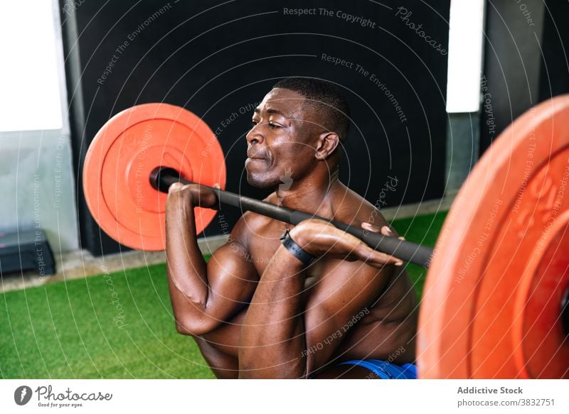 Schwarzer athletischer Mann hebt Langhantel im Fitnessstudio Gewichtheben Curl-Hantel schwer Sportler muskulös Torso Bodybuilder stark männlich ethnisch schwarz
