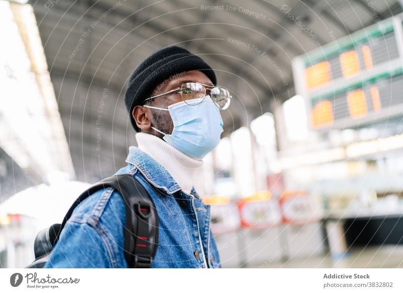 Schwarzer Mann mit Maske am Bahnhof Zug Station reisen Tourist medizinisch Mundschutz Coronavirus neue Normale männlich ethnisch schwarz Afroamerikaner