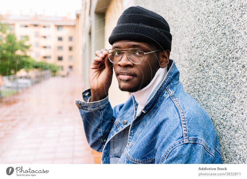 Stilvoller schwarzer Mann auf der Straße Brille angezogen Jeansstoff Outfit Jacke trendy jung männlich ethnisch Afroamerikaner Großstadt modern selbstbewusst