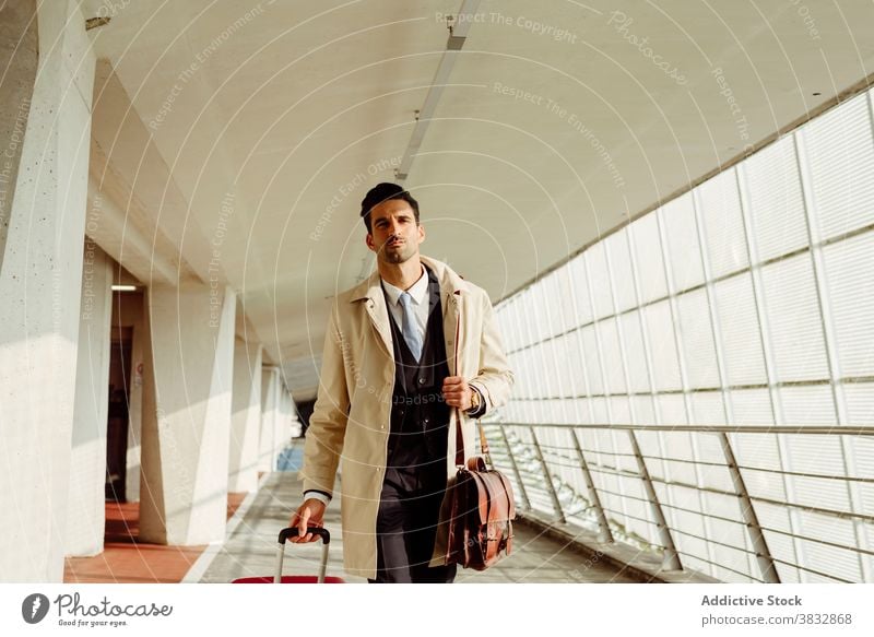Stylish Mann zu Fuß entlang Flughafen ernst selbstbewusst Stil Koffer besinnlich nachdenklich Gang Gepäck männlich ethnisch Spaziergang modern Abheben Tasche