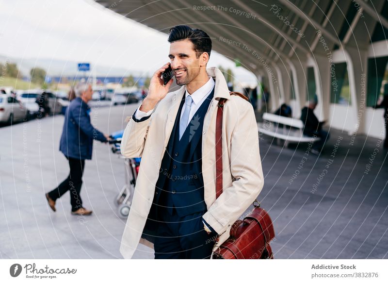 Nachdenklicher Mann spricht am Telefon in der Nähe des Flughafens sprechen trendy Straße Stil Geschäftsmann Konzentration männlich nachdenklich tagsüber