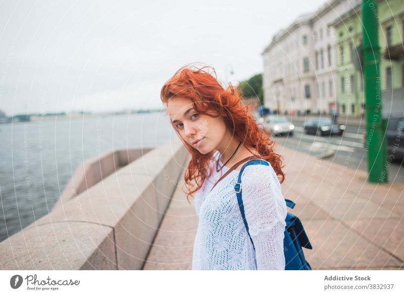 Frau genießt frischen Wind in der Nähe des Flusses in der Stadt urban Freiheit Reisender genießen Brücke Sightseeing rote Haare Rotschopf Tourist
