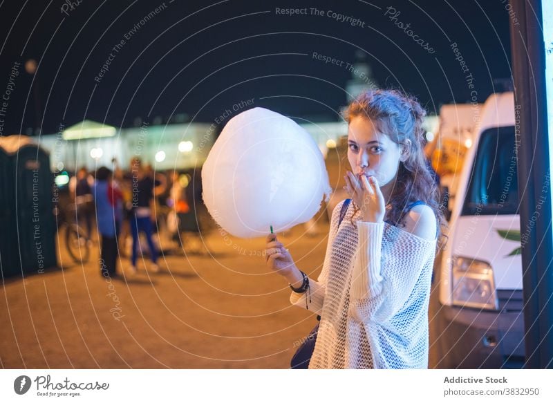 Junge Frau genießt Zuckerwatte in der Nacht Stadt essen Großstadt urban Glück süß genießen Dämmerung tausendjährig Schüler jung heiter Lifestyle