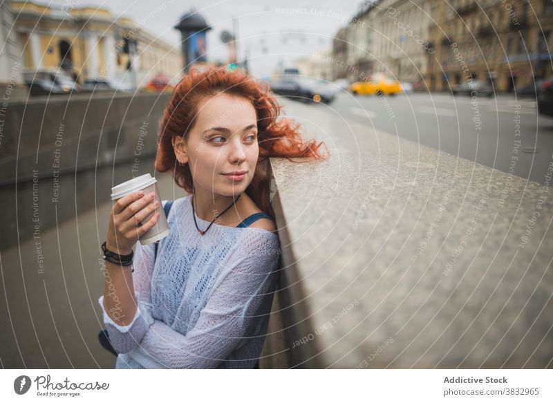 Junge Frau mit Kaffee zum Mitnehmen ruht auf der Straße der Stadt Imbissbude Großstadt sich[Akk] entspannen ruhen nachdenklich trinken Rotschopf positiv