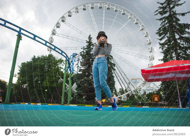 Junge Frau fotografiert mit Kamera im Vergnügungspark Reisender fotografieren sofort Fotoapparat Vergnügen Park Riesenrad Hipster schießen Fotografie jung