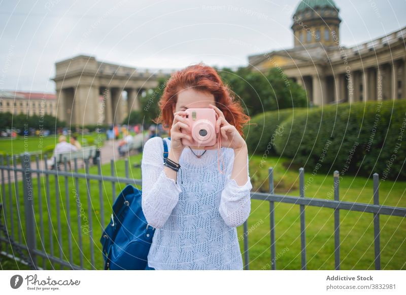 Weiblicher Tourist fotografiert mit Sofortbildkamera in der Nähe der alten Kathedrale Frau Reisender fotografieren sofort Fotoapparat berühmt schießen