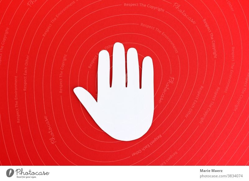 Halt! Stop-Hand aus Papier auf rotem Hintergrund stoppen Stoppschild Verbot Verbotsschild Schild Zeichen Symbole & Metaphern Gefahr Warnung Hinweis Warnhinweis