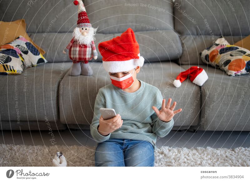 Kleiner Junge macht zu Weihnachten einen Videoanruf allein Anruf Feier Talkrunde Kind Kindheit Computer Konzept Korona Coronavirus COVID COVID19 Gerät