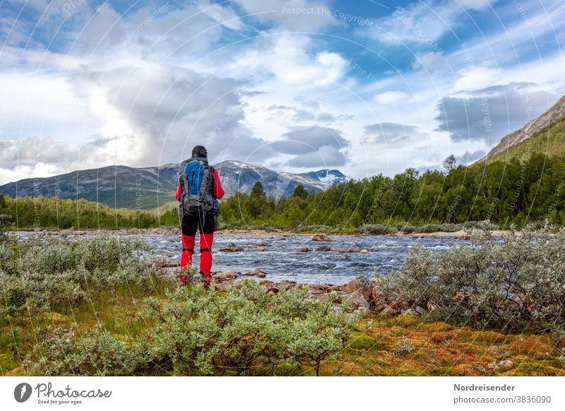 Rucksacktourismus in der Wildnis von Skandinavien frau wandern trekking rucksack abenteuer reise wasser unterwegs wildnis camping fluss pause auszeit wald berge