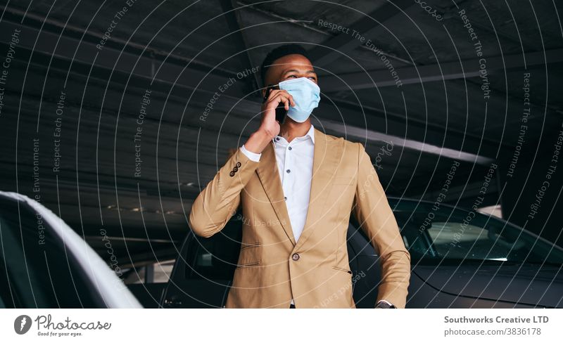 Geschäftsmann trägt während einer Gesundheitspandemie Maske mit Mobiltelefon auf dem Flughafen-Parkplatz Business Gesichtsmaske Gesichtsbedeckung tragend ppe
