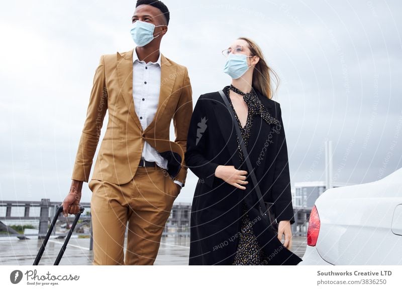 Geschäftspaar trägt Masken außerhalb des Flughafens auf Geschäftsreise mit Gepäck während einer Gesundheitspandemie Business Geschäftsmann Geschäftsfrau