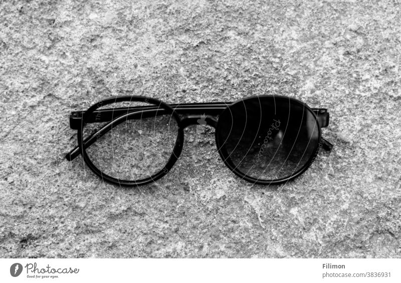 Augenglas mit einer gebrochenen Linse Brille Sonnenbrille schwarz auf weiß fallen gelassen Schwarzweißfoto
