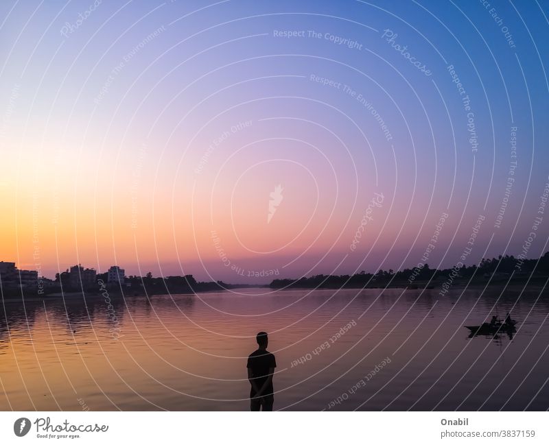 Mann steht in der Mitte des Flusses Stehen Sonnenuntergang farbenfroh Landschaft Stillleben expressiv Natur Farbfoto Ferien & Urlaub & Reisen Flussufer Wasser