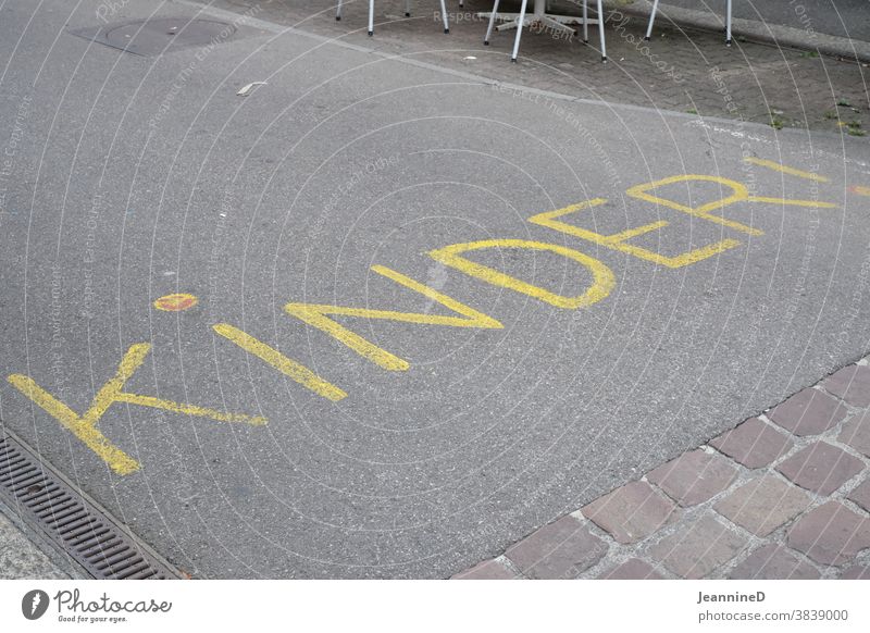 Strasse mit gelben Text, Kinder! Schriftzug Boden Wort Menschenleer Straße Warnung Achtung Hinweis Spielstraße Hinweisschild aufgemalt Handschrift Vorsicht