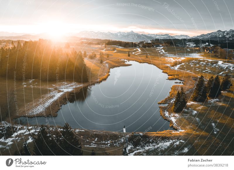 Sonnenaufgang über einem Bergsee Allgäu Bayern Berge Deutschland Drohne Europa Grundweiher Landschaft Luftaufnahme Natur See Weiher Wasser Sonnenstrahlen