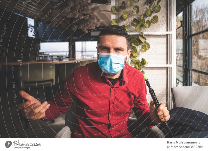 Mann mit Gesichtsmaske, der versucht, Shishapfeife zu rauchen Sucht Erwachsener Aroma Kunst asiatisch Hintergrund Bar schwarz blau atmen Café Holzkohle