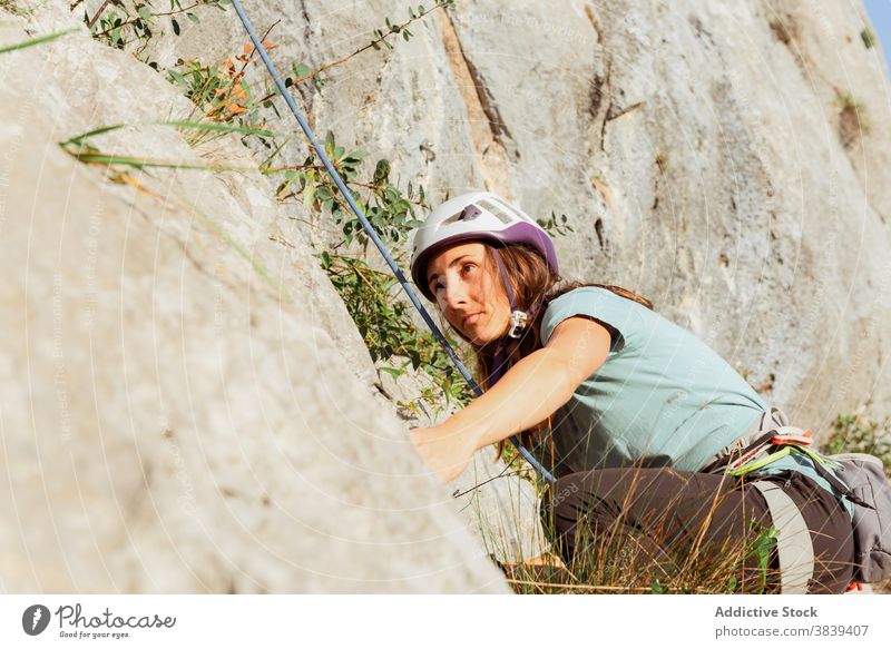 Weibliche Kletterin beim Aufstieg an steilem Felsen im Sommer Aufsteiger aufsteigen steile Klippe Frau Alpinist Berge u. Gebirge üben Klettern aktiv Bergsteigen