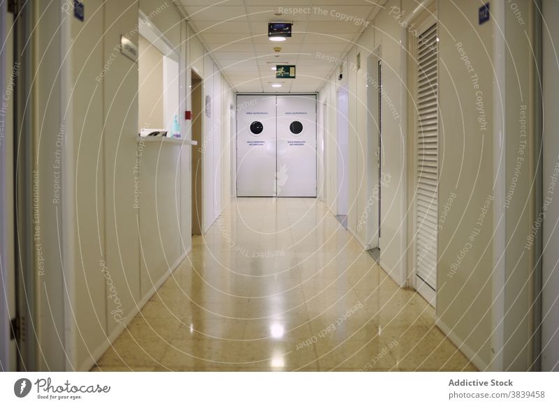 Leerer Korridor mit glänzendem Boden im Krankenhaus Gang leer Licht Stock Fliesen u. Kacheln Tür Reflexion & Spiegelung modern Klinik Einsamkeit leuchten Lampe