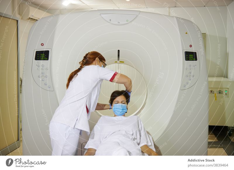 Unbekannter Radiologe und Patient am Tomographiegerät in der Klinik Radiologin geduldig Gerät Diagnostik Gesundheitswesen Uniform Mundschutz professionell