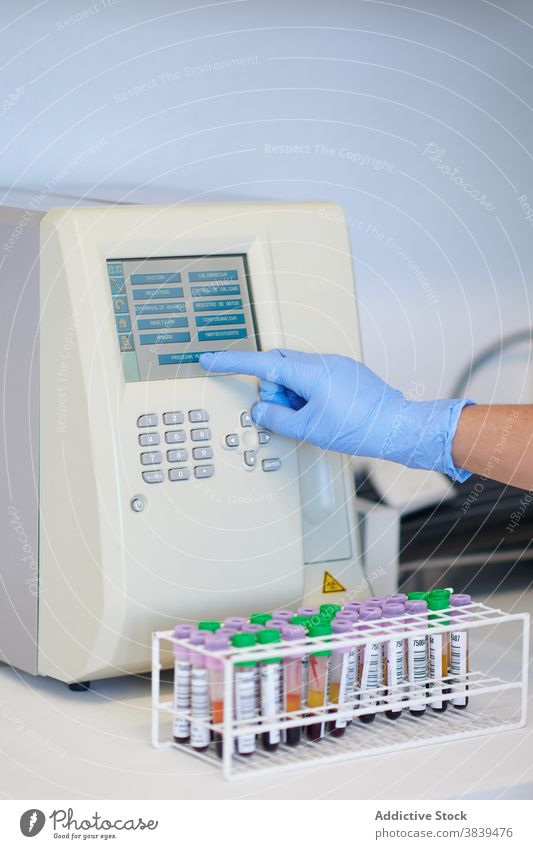 Pflanzenwissenschaftler mit Blutanalysegerät in der Nähe von Röhrchen im Labor Wissenschaftler Analysator Tube Anzeige Analyse Gerät medizinisch modern