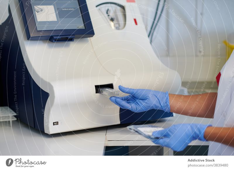 Pflanzenwissenschaftler legt Blutprobe in Hämatologie-Analysegerät im Labor Spezialist Analysator Probe medizinisch Prüfung Gerät Monitor Diagnostik Frau