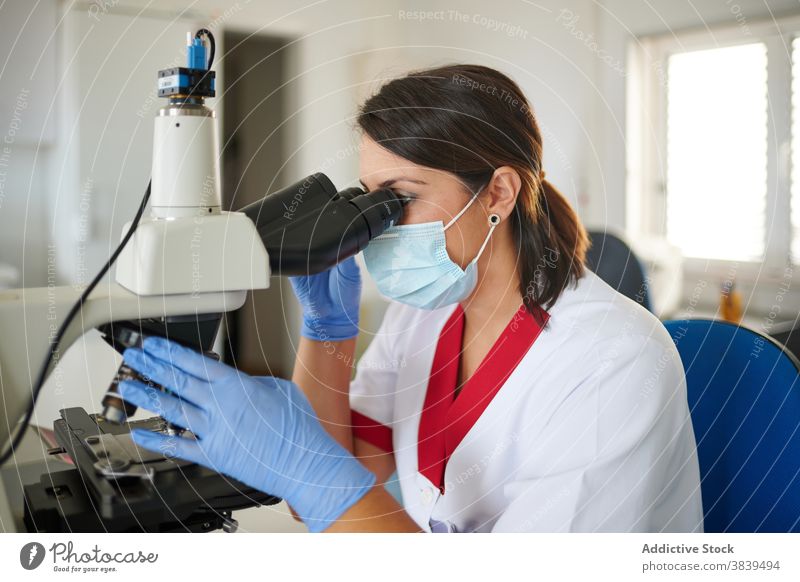 Anonyme Wissenschaftler mit Mikroskop bei der Analyse im Labor Arbeit Prozess Mitarbeiterin medizinisch Uniform Frauen Gerät Diagnostik Klinik professionell