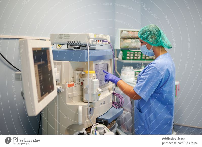 Nicht erkennbarer Arzt, der das Display eines Diagnosegeräts im Labor berührt Monitor Gerät Diagnostik wählen medizinisch Uniform Frau Klinik professionell