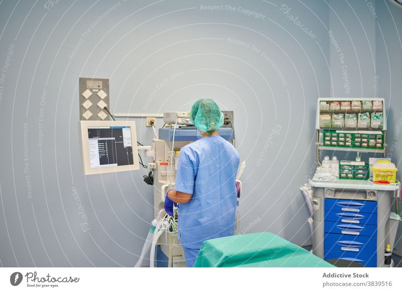 Nicht erkennbarer Arzt, der das Display eines Diagnosegeräts im Labor berührt Monitor Gerät Diagnostik wählen medizinisch Uniform Frau Klinik professionell