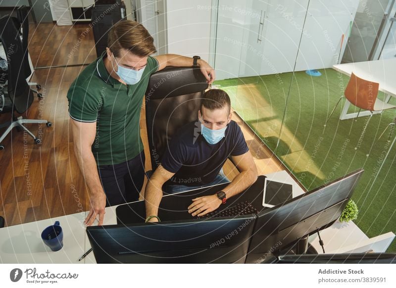 Männliche Software-Entwickler arbeiten gemeinsam im Büro programmieren Code Entwicklung Kollege Mitarbeiterin Programmierer Programmierung Coronavirus Pandemie