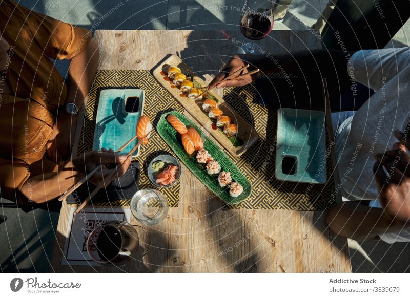 Crop schwarze Frauen am Tisch mit Sushi im Restaurant rollen Asiatische Küche Café essen verschiedene sortiert Kulisse ethnisch Afroamerikaner Speise