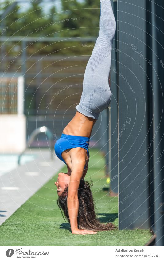 Schlanke Frau macht Handstand beim Training Wand Sportlerin akrobatisch Sommer Gleichgewicht passen Fitness Sportbekleidung Wellness Gesundheit Übung beweglich