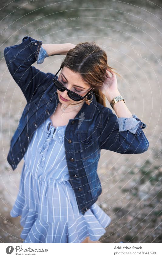 Stilvolle Frau in Jeansjacke in der Natur Jeansstoff Jacke sorgenfrei ruhig trendy cool Sonnenbrille lässig Mode jung ruhen genießen sich[Akk] entspannen
