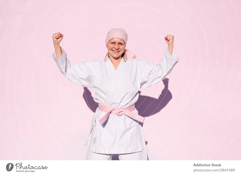 Karatefrau, die den Krebs besiegt hat Frau kämpferisch Kunst Sport Kampagne Erkenntnis Gesundheit Kämpfer rosa Foulard selbstbewusst Krankheit heiter Vergebung