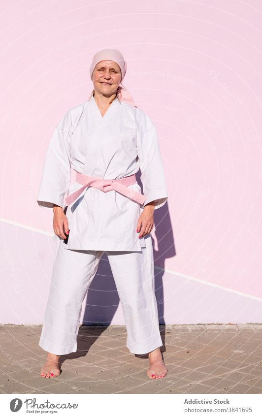 Karatefrau, die den Krebs besiegt hat Frau kämpferisch Kunst Sport Kampagne Erkenntnis Gesundheit Kämpfer rosa Foulard selbstbewusst Krankheit Vergebung stark