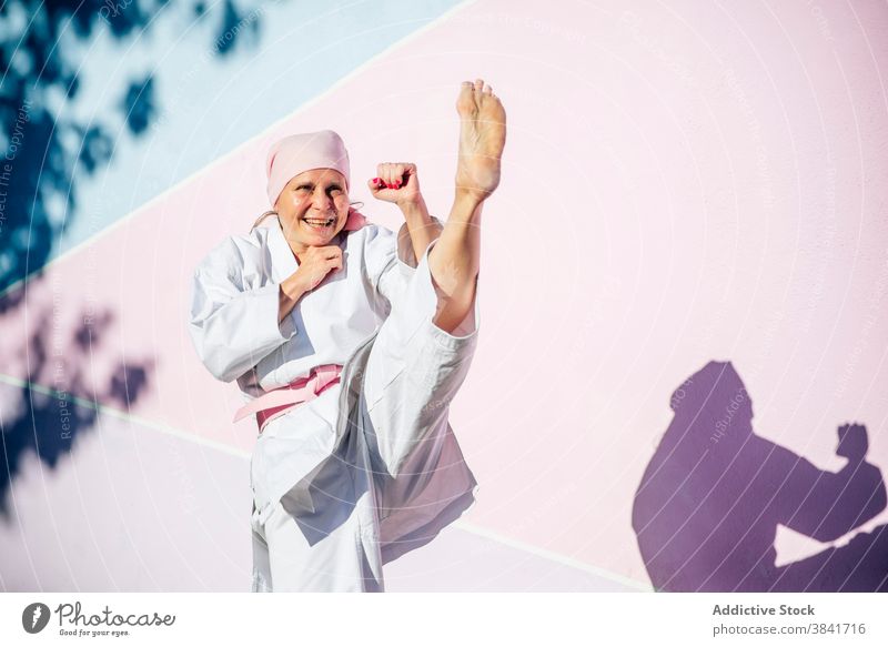 Karatefrau, die den Krebs besiegt hat Frau kämpferisch Kunst Sport Kampagne Erkenntnis Gesundheit Kämpfer rosa selbstbewusst Krankheit Vergebung stark Onkologie