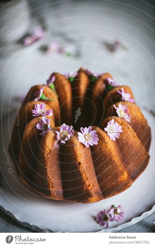 Appetitlicher Bundt-Kuchen mit Blumen auf dem Tisch Bundkuchen geschmackvoll Dekoration & Verzierung dienen Dessert süß lecker Küche Teller frisch Feinschmecker