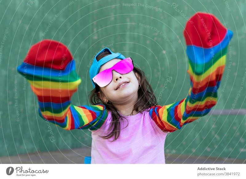Fröhliches Mädchen mit Regenbogen Socken auf der Straße Kniestrümpfe Streifen farbenfroh spielen Kind Spaß haben kreativ Outfit Hipster spielerisch Freude hell