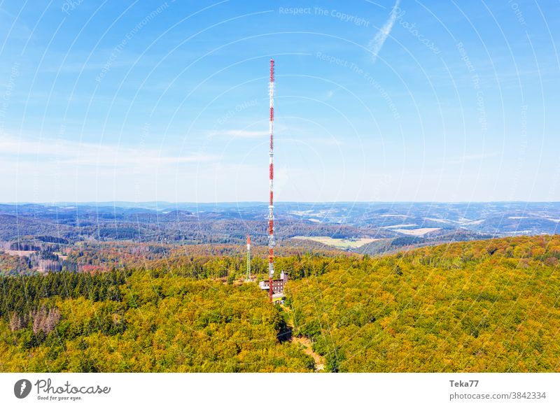 ein großer Funkturm auf dem Gipfel eines Berges Turm Radio Großantenne Antenne Waldhügel Hügel Baum Bäume grün gelb orange Berge u. Gebirge