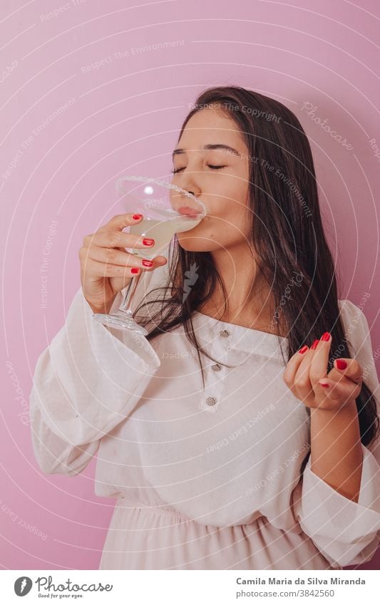 junge Frau trinkt einen Cocktail - Rosenhintergrund Erwachsener Alkohol Hintergrund schön Schönheit Getränk heiter Nahaufnahme cool trinken Mädchen Glas