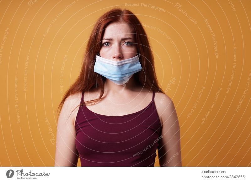 junge Frau, die Mundschutz Maske falsch unter der Nase trägt Corona Corona-Leugner Gesichtsmaske Korona-Verweigerer COVID Coronavirus leugnen protestieren