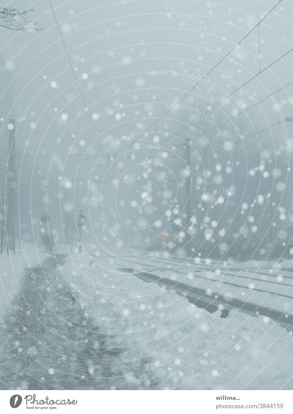 Es schneit in der Stadt, Flockenwirbel. Schneegestöber Winter Schneefall Schneeflocken Straße Fußweg Bahngleise Schneematsch Schneetreiben winterlich kalt